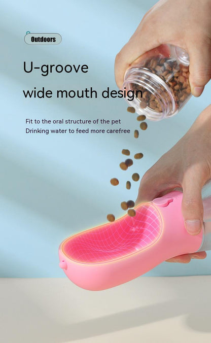 Pink pet feeder with a hand pouring food into it against a light blue background